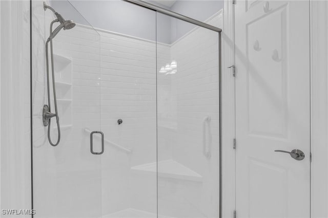 bathroom featuring a shower with shower door