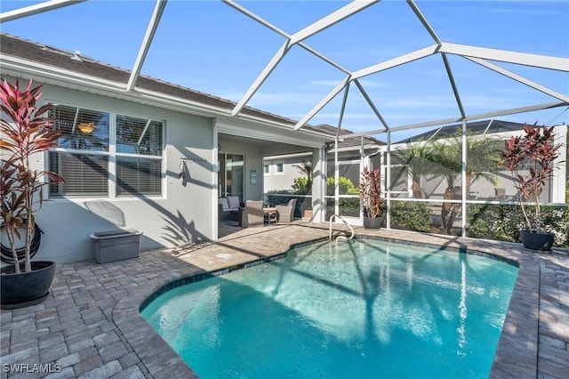 view of pool with glass enclosure and a patio