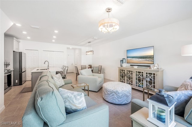 tiled living room featuring a chandelier and sink