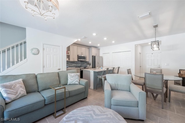 living room featuring light tile patterned floors and an inviting chandelier