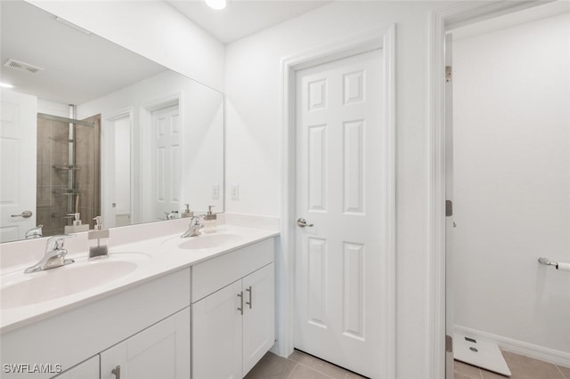 bathroom with tile patterned floors, vanity, and a shower with shower door