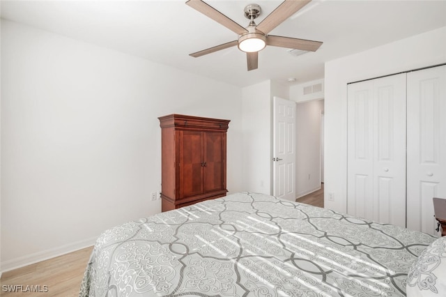 bedroom with ceiling fan, light wood-type flooring, and a closet