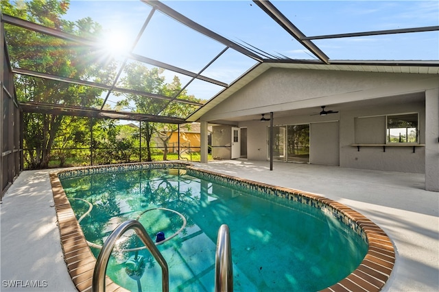 view of swimming pool with glass enclosure, ceiling fan, and a patio