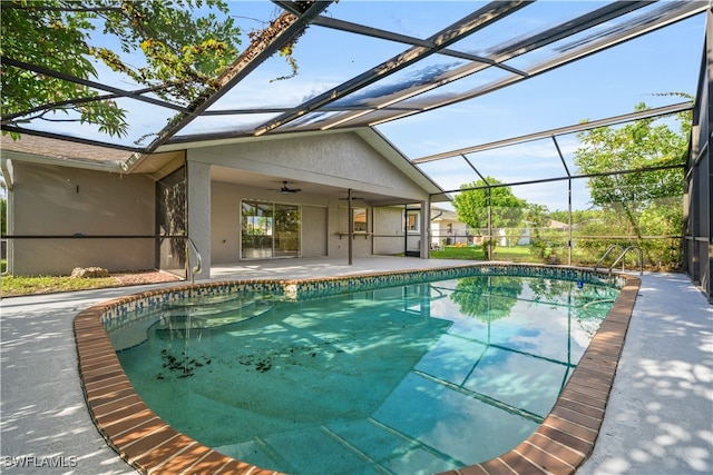 view of pool featuring glass enclosure, ceiling fan, and a patio area