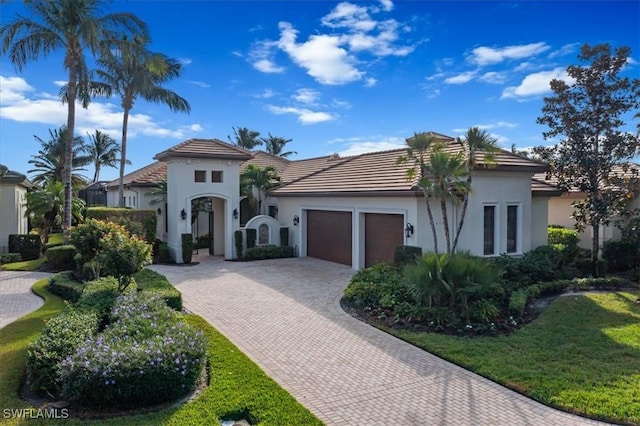 mediterranean / spanish-style house featuring a garage and a front yard