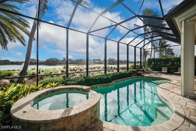 view of swimming pool with an in ground hot tub, a patio, a water view, and a lanai