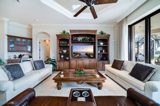 living room with ceiling fan, light wood-type flooring, and ornamental molding