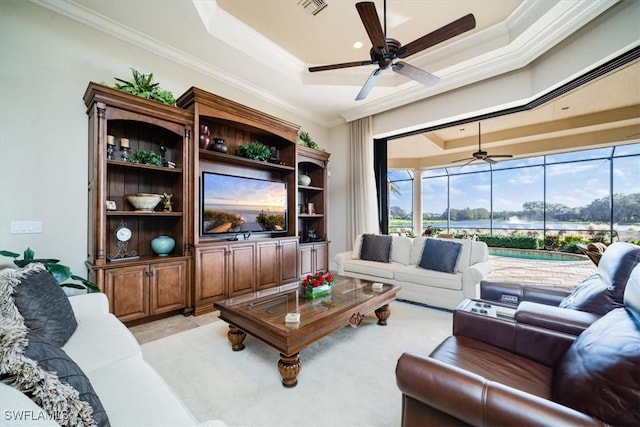 living room featuring a tray ceiling, crown molding, ceiling fan, and a healthy amount of sunlight