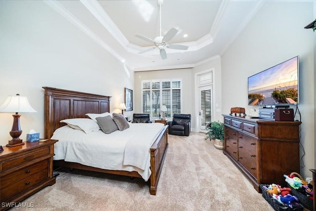 bedroom with ceiling fan, light colored carpet, ornamental molding, and a tray ceiling