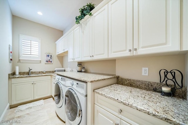 washroom featuring cabinets, washer and clothes dryer, and sink