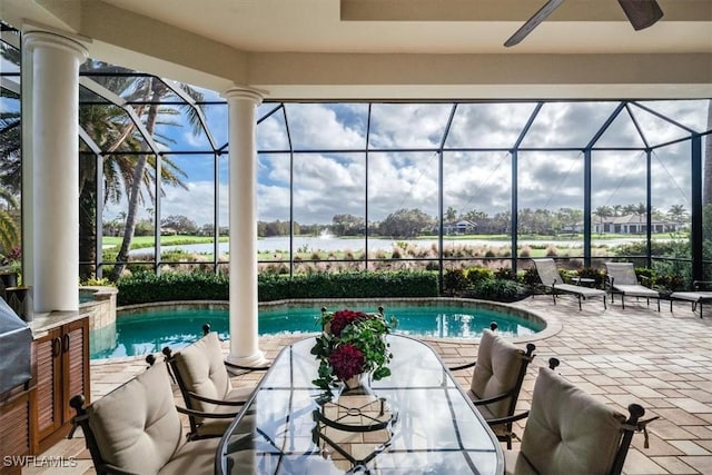 view of swimming pool with a patio, glass enclosure, and ceiling fan