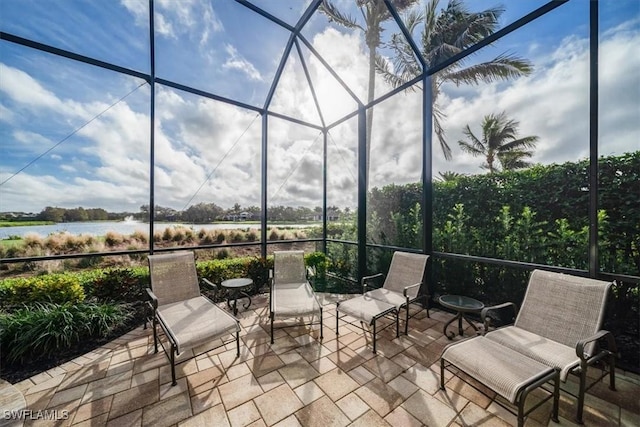 view of patio with a water view and glass enclosure