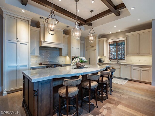 kitchen with a large island, light wood-type flooring, and hanging light fixtures