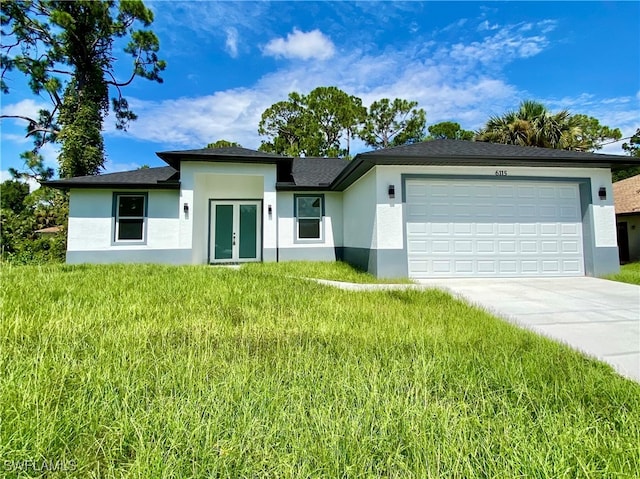 view of front of property featuring a garage, a front yard, and french doors