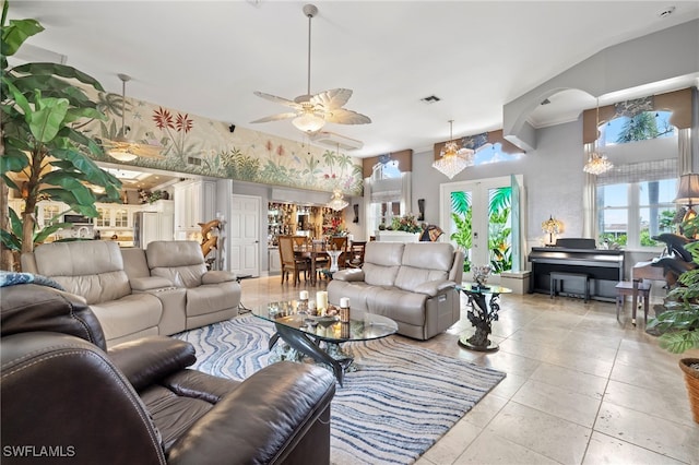 tiled living room with ceiling fan with notable chandelier