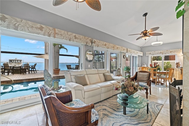 living room with a water view, ceiling fan, and lofted ceiling