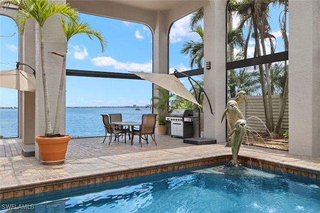 view of swimming pool with pool water feature, a water view, a patio, and grilling area