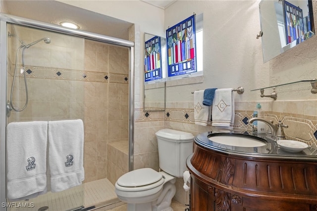 bathroom with vanity, an enclosed shower, tile walls, and toilet