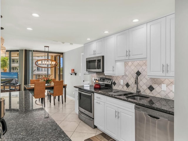 kitchen featuring white cabinetry, sink, hanging light fixtures, and appliances with stainless steel finishes