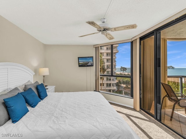 carpeted bedroom with ceiling fan and a textured ceiling