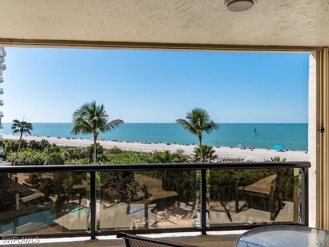 balcony featuring a beach view and a water view