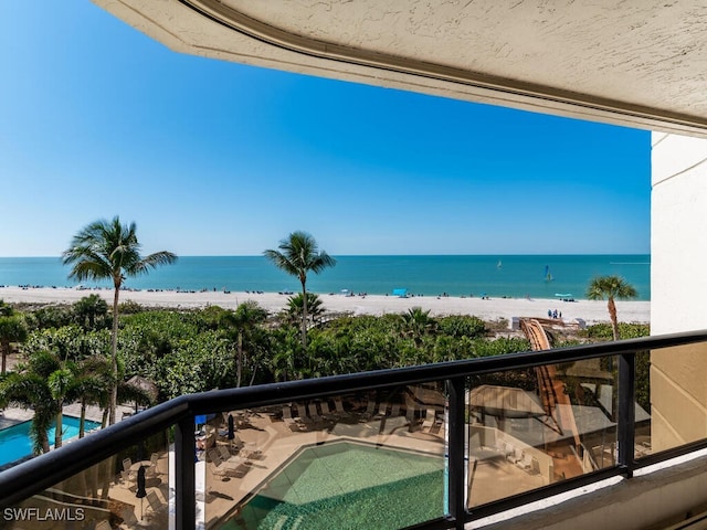 balcony with a water view and a beach view