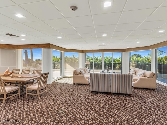 carpeted living room featuring a paneled ceiling and plenty of natural light