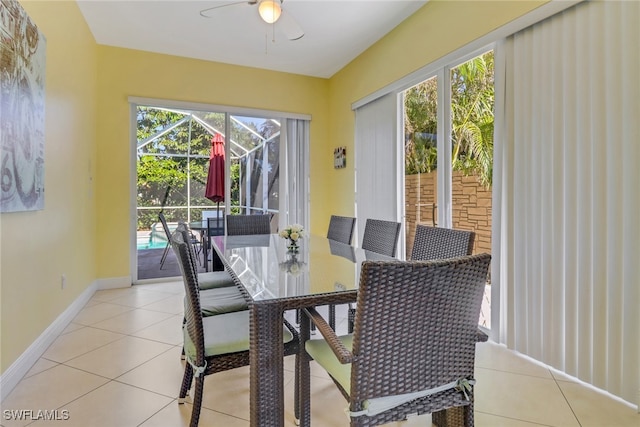 dining area with a sunroom, ceiling fan, baseboards, and light tile patterned floors