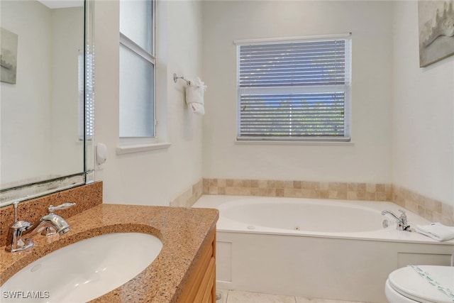 bathroom featuring toilet, vanity, and a bath