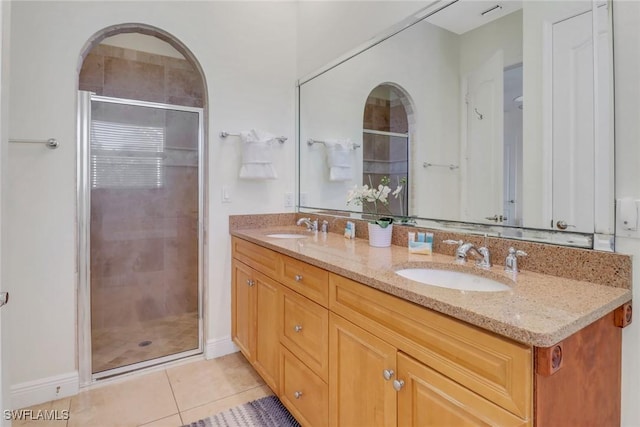 full bath with a stall shower, a sink, and tile patterned floors