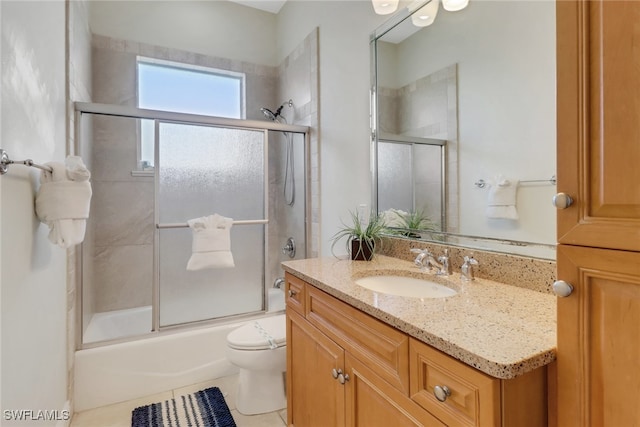 bathroom with toilet, tile patterned flooring, combined bath / shower with glass door, and vanity