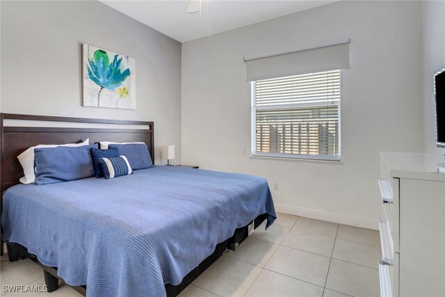 bedroom featuring light tile patterned floors, a ceiling fan, and baseboards