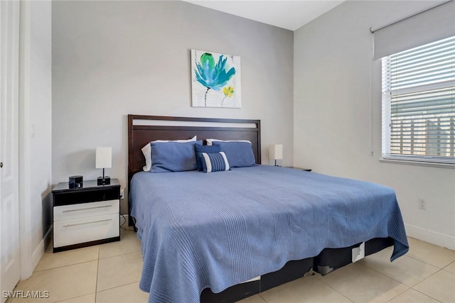 bedroom featuring light tile patterned flooring and baseboards