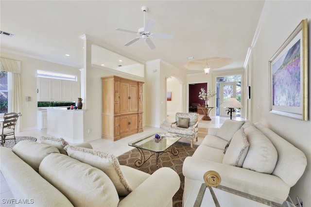 living room featuring ceiling fan, light tile patterned floors, and ornamental molding