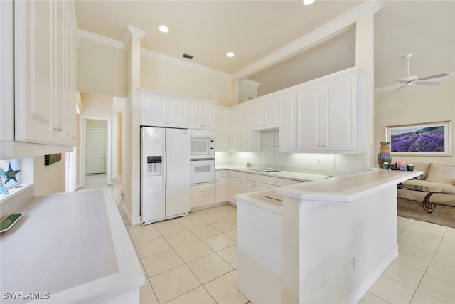 kitchen featuring white cabinets, light tile patterned flooring, white appliances, and kitchen peninsula