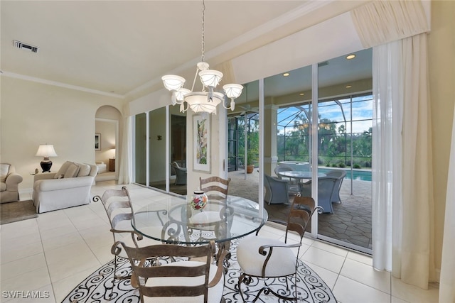 tiled dining space with crown molding and an inviting chandelier