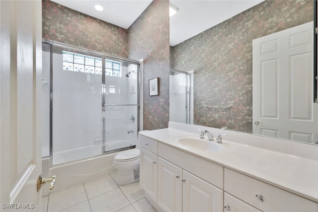 full bathroom featuring tile patterned flooring, vanity, toilet, and shower / bath combination with glass door