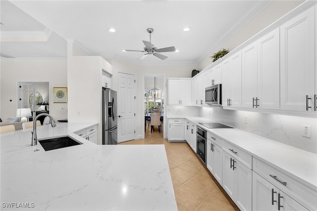 kitchen featuring white cabinets, appliances with stainless steel finishes, light stone countertops, and sink