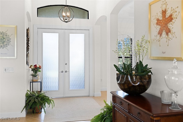 tiled entryway featuring a chandelier and french doors