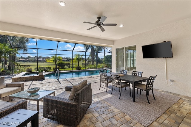 view of patio / terrace with glass enclosure, ceiling fan, a swimming pool with hot tub, and an outdoor living space