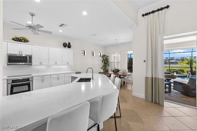 kitchen featuring white cabinetry, sink, crown molding, and appliances with stainless steel finishes