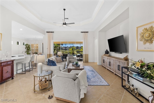 tiled living room featuring ceiling fan, ornamental molding, and a tray ceiling