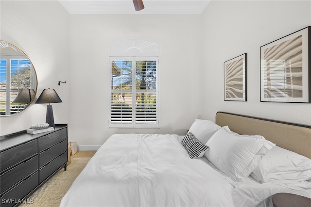 carpeted bedroom with ceiling fan and ornamental molding