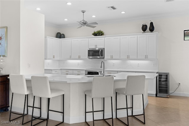 kitchen featuring white cabinetry, crown molding, beverage cooler, and sink