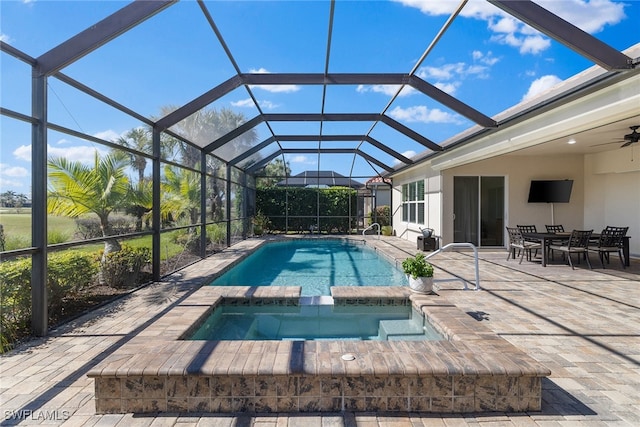 view of pool featuring glass enclosure, an in ground hot tub, and a patio