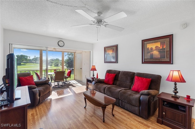 living room with a textured ceiling, wood finished floors, and a ceiling fan