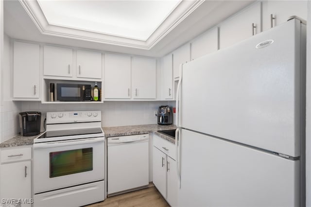 kitchen featuring white appliances, a tray ceiling, and white cabinetry