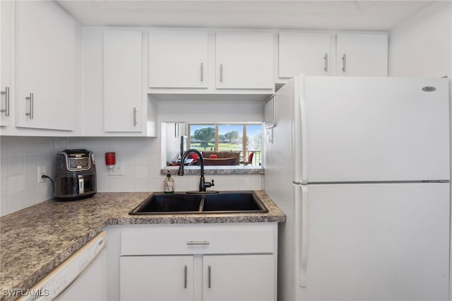 kitchen with white appliances, a sink, white cabinetry, and decorative backsplash