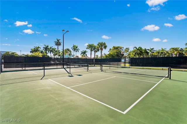 view of tennis court featuring fence