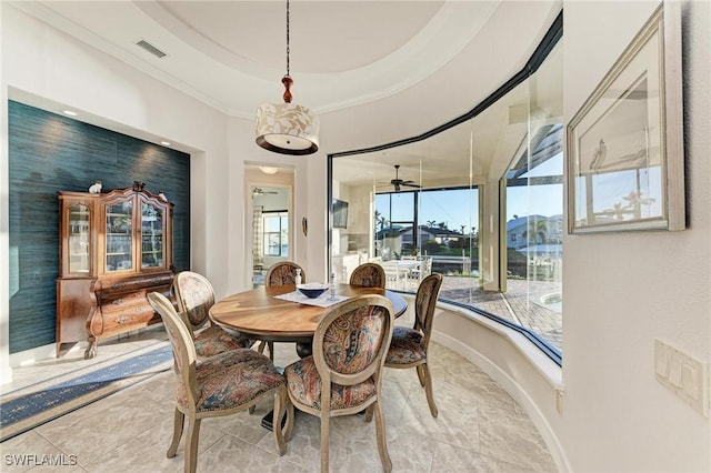 dining room featuring a raised ceiling and ornamental molding